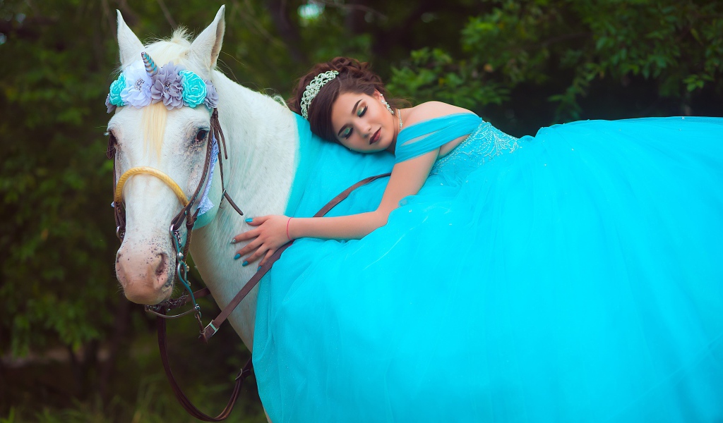 Красивая девушка в пышном голубом платье на лошади