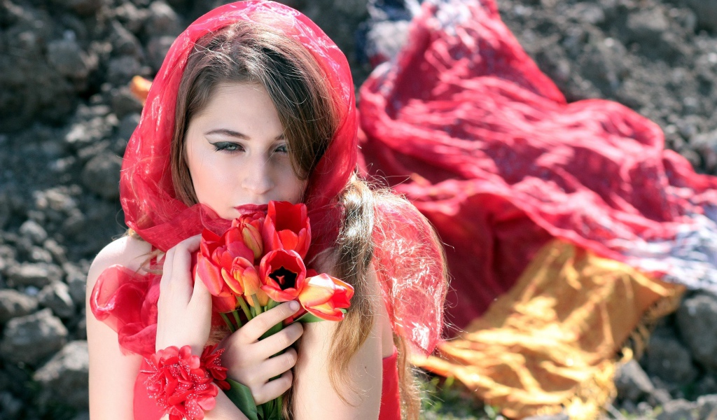 Красивая девушка в красной шали с букетом тюльпанов