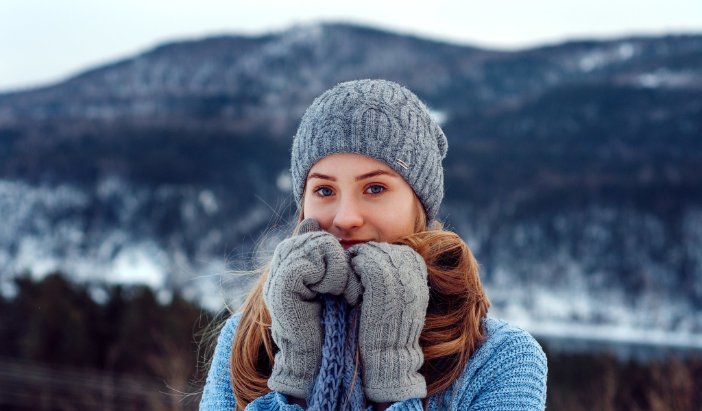 Красивая девушка в теплой шапке и варежках