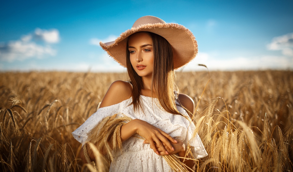 Красивая девушка в белом платье с колосьями пшеницы