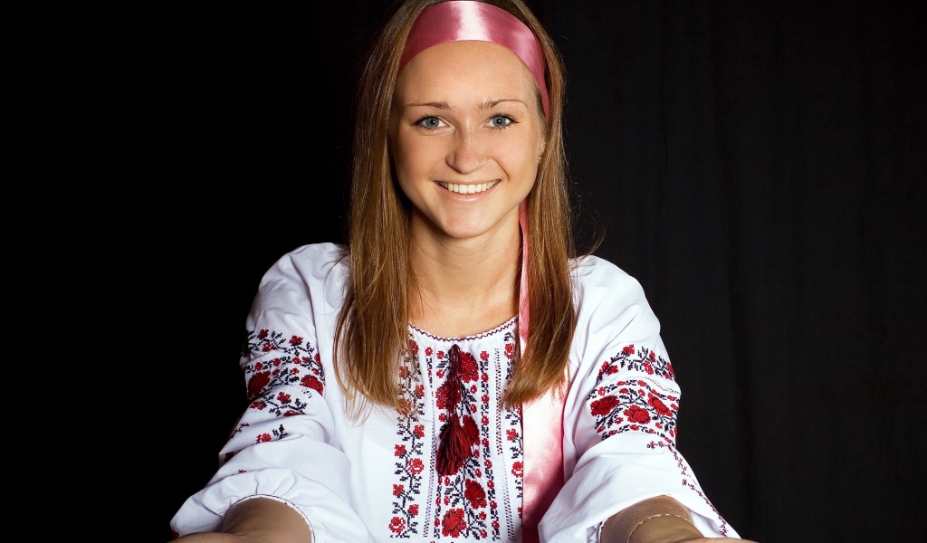 Красивая девушка в вышитой рубашке на черном фоне