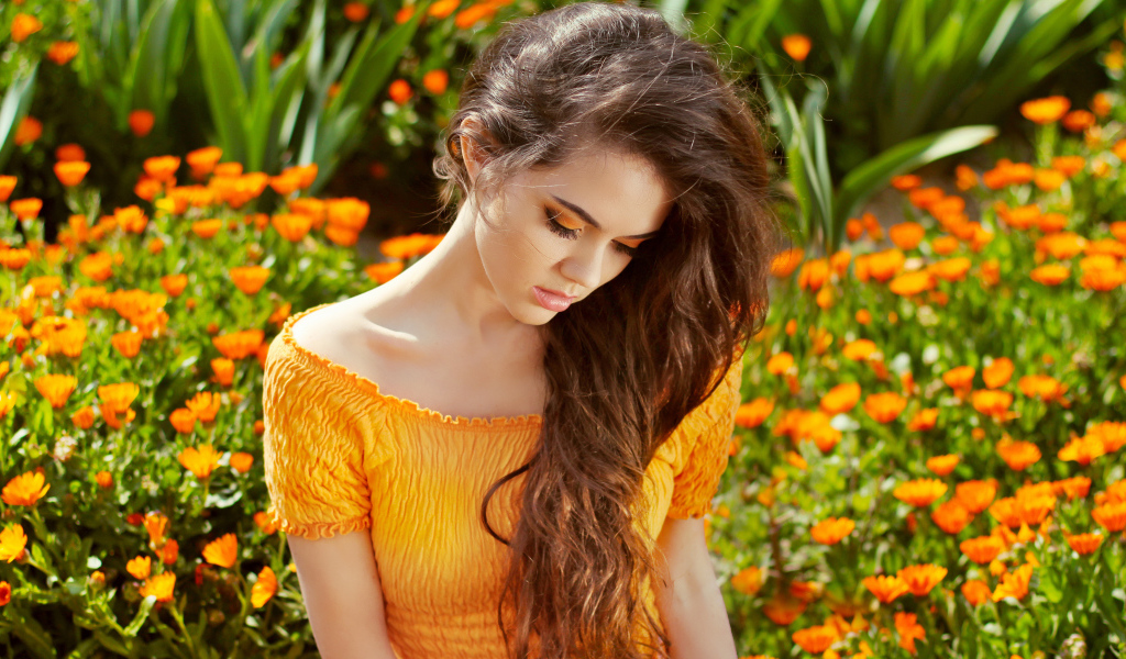 Красивая девушка у цветов календулы