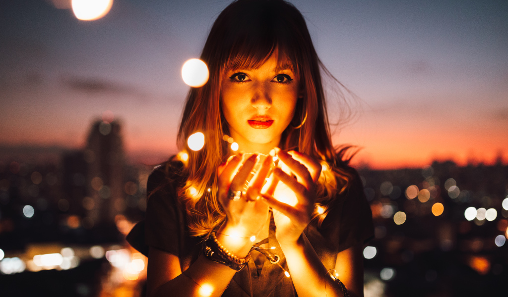 Красивая девушка с включенной гирляндой в руках 