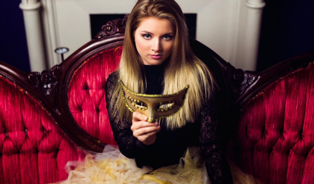 Красивая девушка с маской в руках