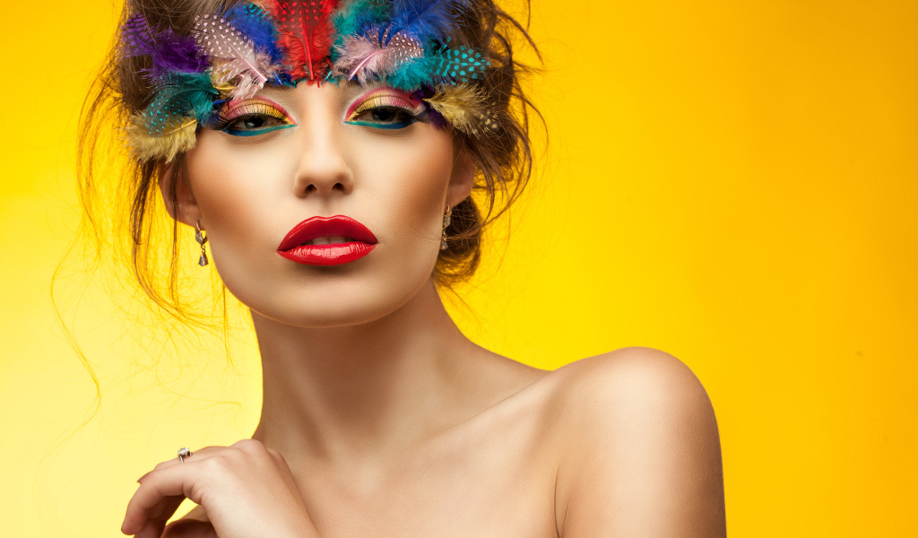 Красивая девушка с ярким макияжем на желтом фоне