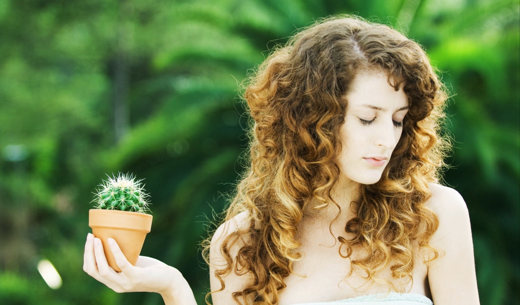 Красивая девушка с закрытыми глазами с кактусом в руке