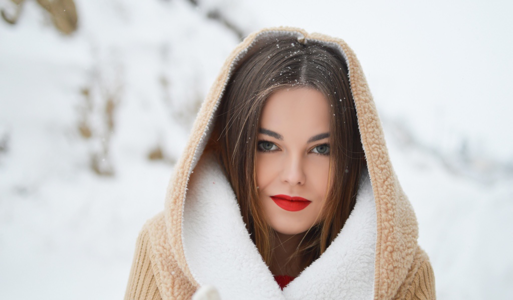 Красивая девушка с красными губами в теплой куртке зимой