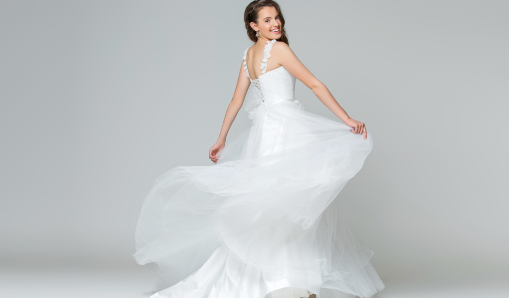 Красивая радостная девушка в белом свадебность платье