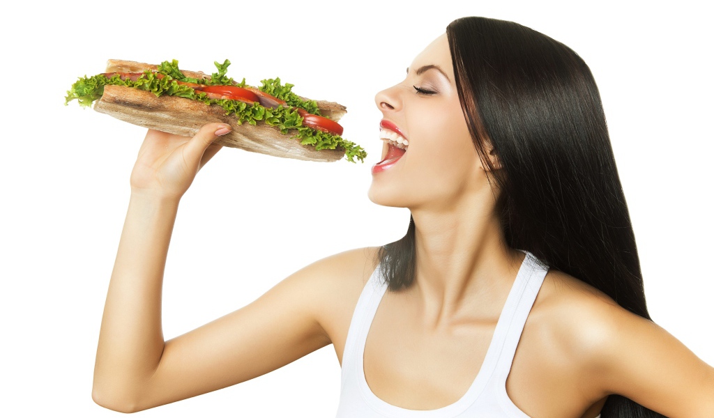 Красивая длинноволосая девушка брюнетка с большим бутербродом 