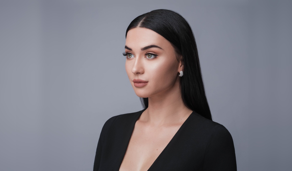 Красивая длинноволосая брюнетка в черном фото на сером фоне