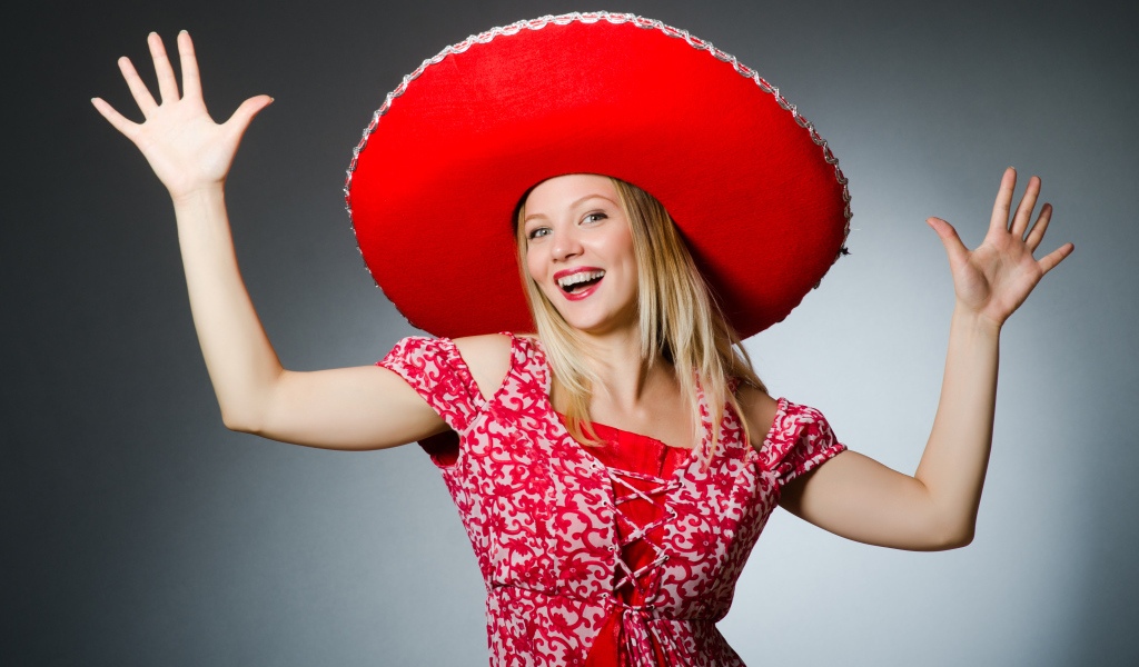 Красивая улыбающаяся блондинка в большой красной шляпе