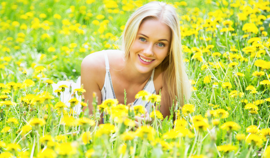 Красивая улыбающаяся блондинка в желтых одуванчиках