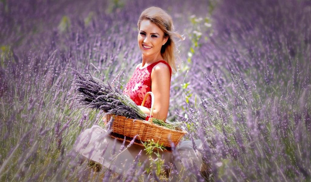 Красивая улыбающаяся девушка с корзиной на лавандовом поле