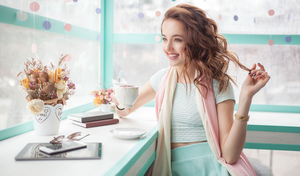 Красивая улыбающаяся девушка шатенка с чашкой кофе