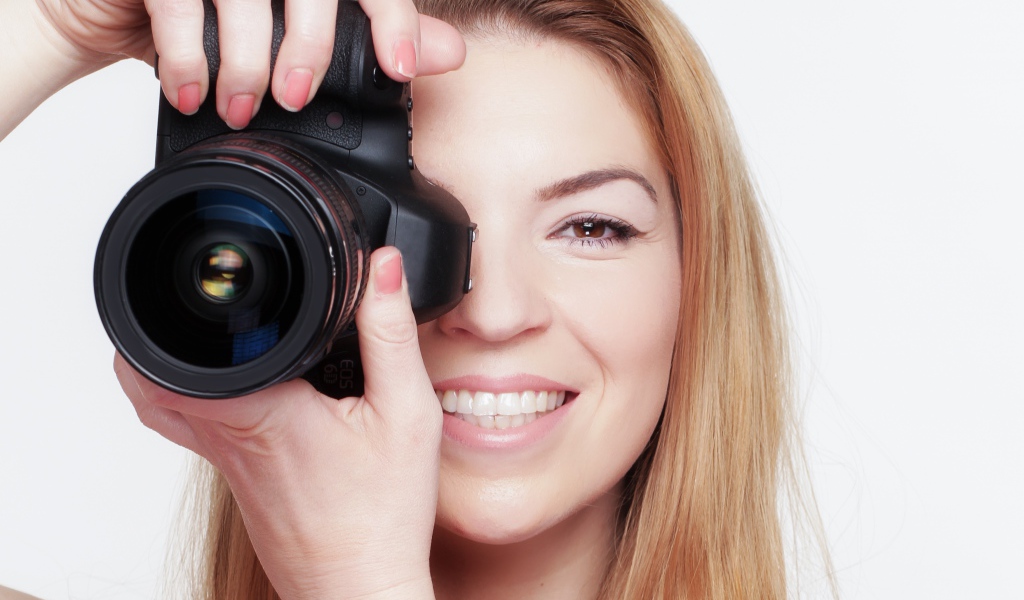 Красивая улыбающаяся девушка с фотоаппаратом
