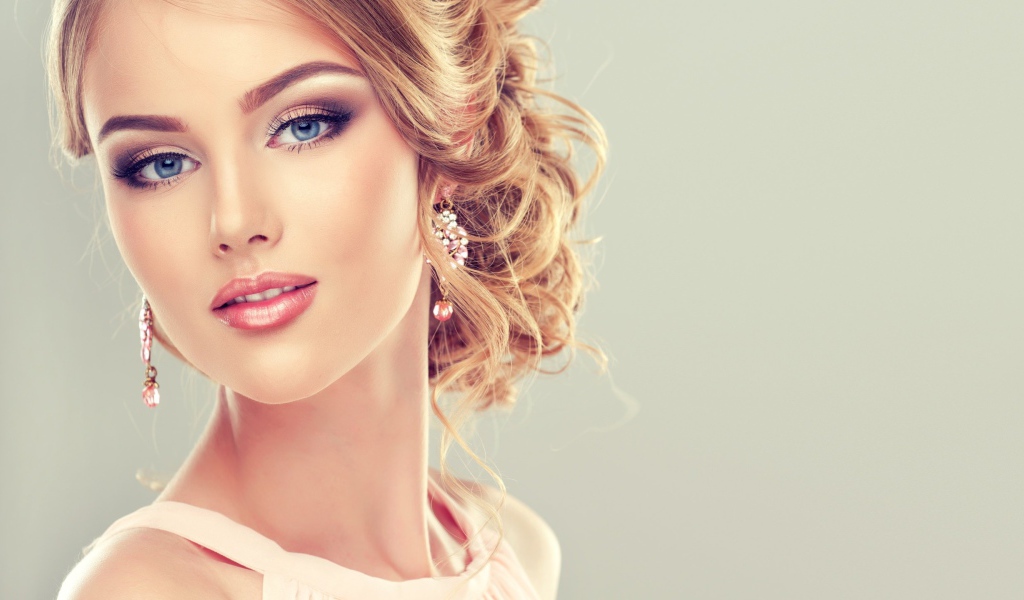 Красивая стильная голубоглазая девушка с красивым макияжем и прической