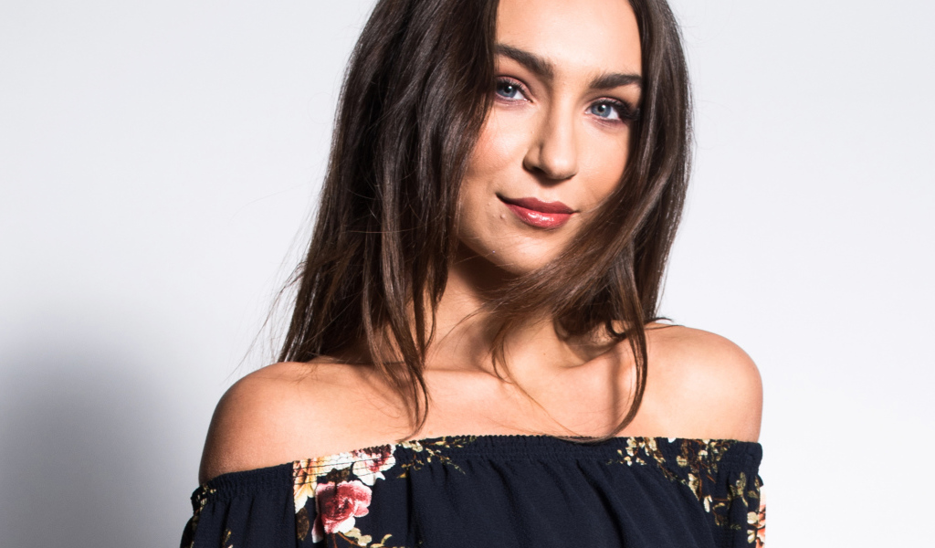 Красивая нежная голубоглазая брюнетка на сером фоне