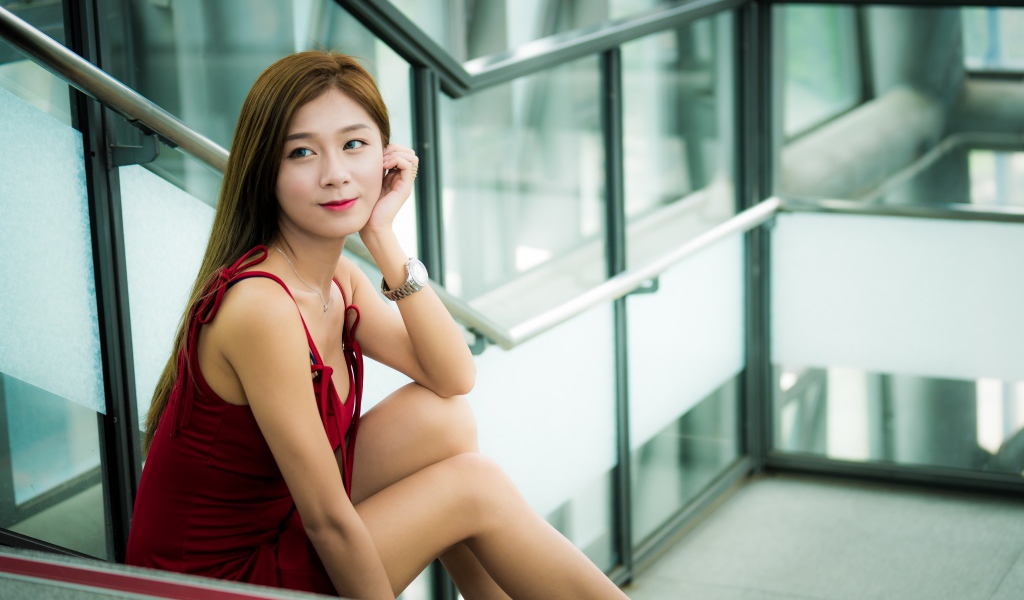 Красивая молодая девушка азиатка сидит на ступенях