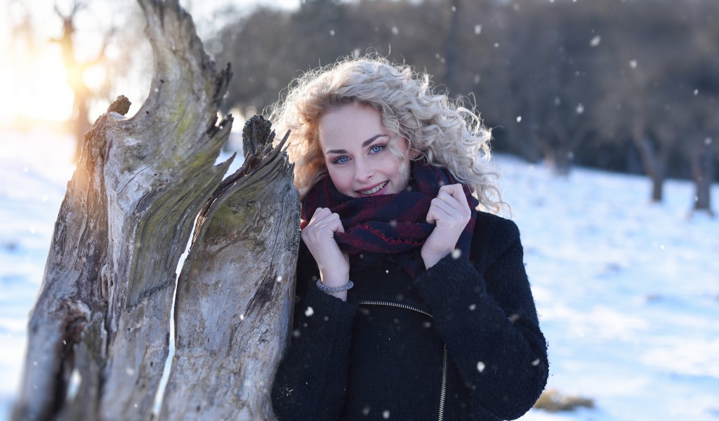 Голубоглазая блондинка у сухого дерева зимой