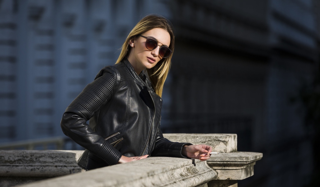 Дерзкая девушка в черной кожаной куртке и очках