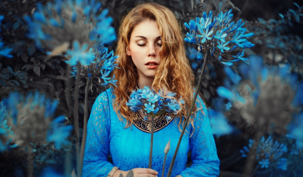 Мечтательная девушка с голубыми цветами 