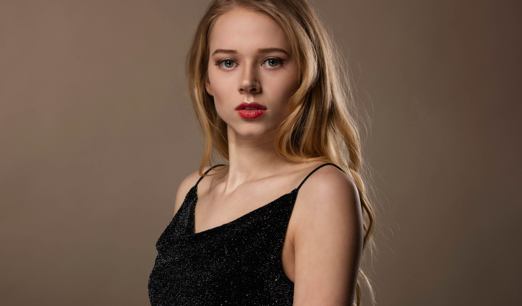 Нежная девушка модель в черном платье на сером фоне
