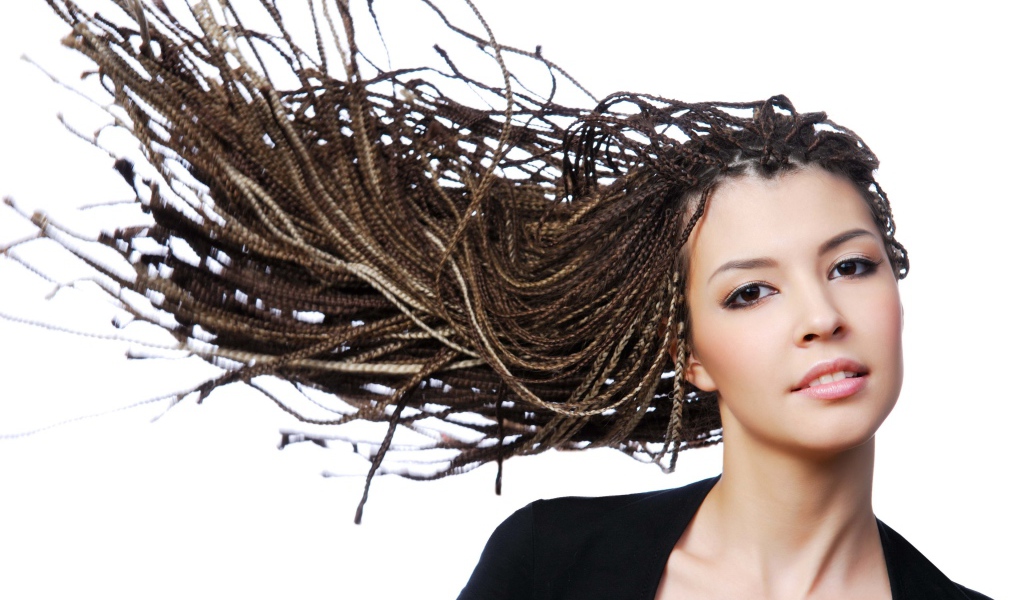 Девушка с прической косичками на голове на белом фоне