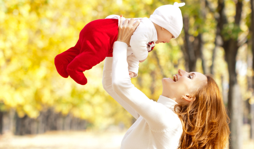 Счастливая девушка с младенцем на руках