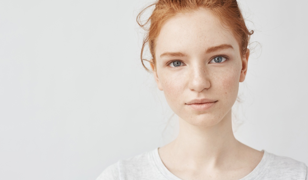 Рыжеволосая девушка на сером фоне