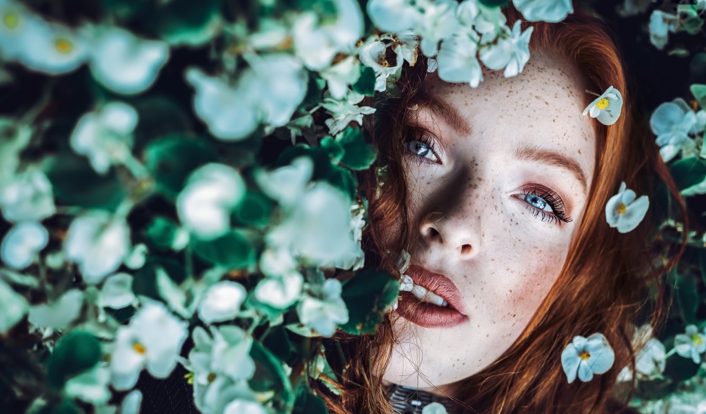 Рыжеволосая девушка с веснушками в белых цветах 