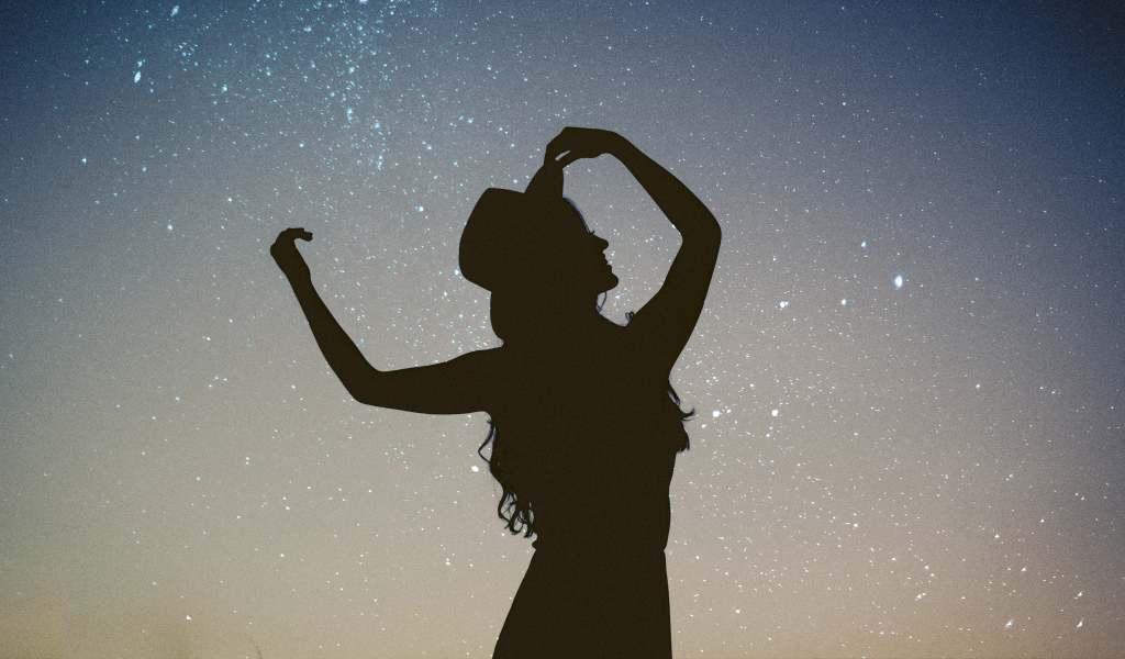 Силуэт девушки в шляпе на фоне неба