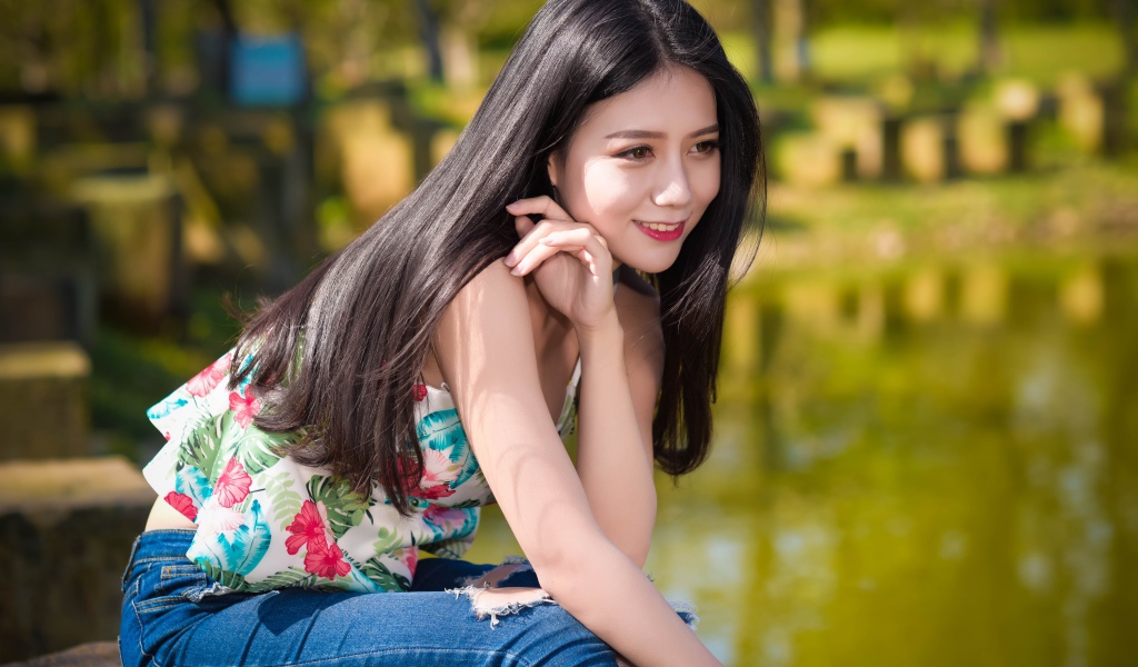 Улыбающаяся красивая девушка азиатка у воды