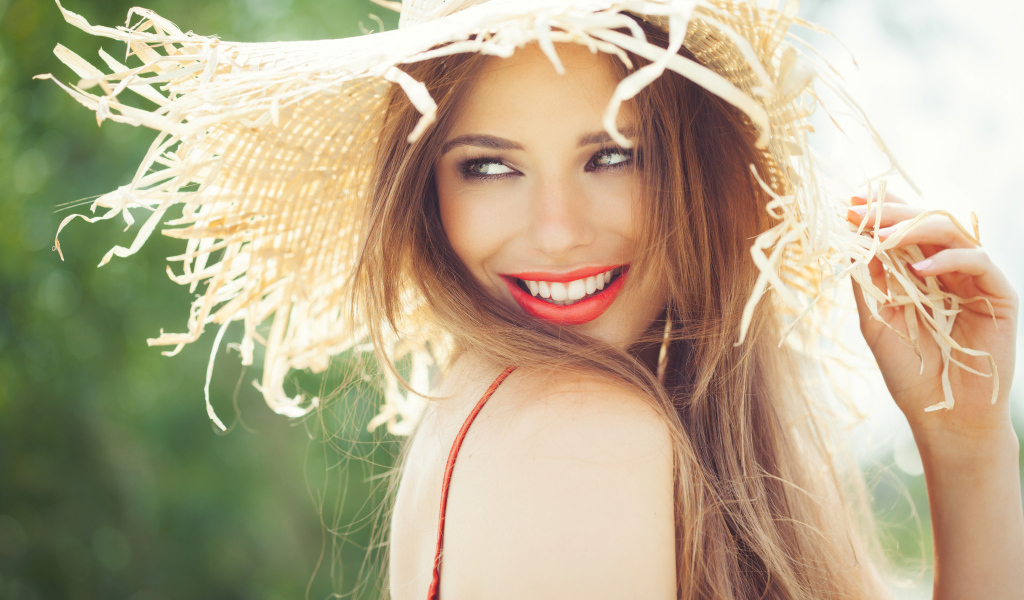 Улыбающаяся девушка в соломенной шляпе летом