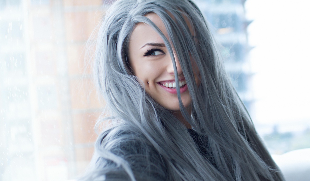 Улыбающаяся эпатажная девушка с пирсингом