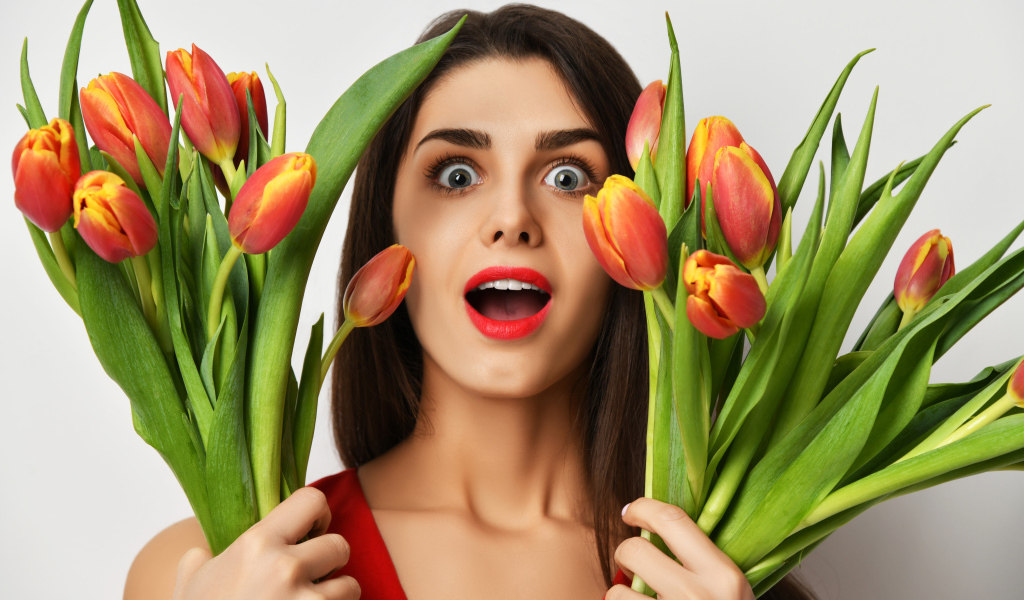 Удивленная шатенка с букетами тюльпанов