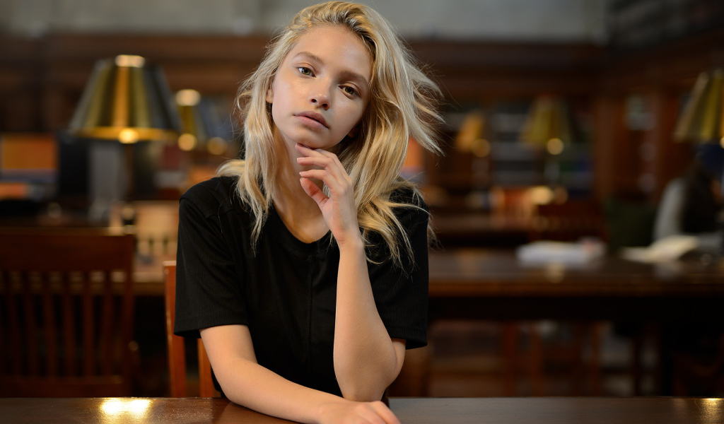 Нежная девушка блондинка в библиотеке