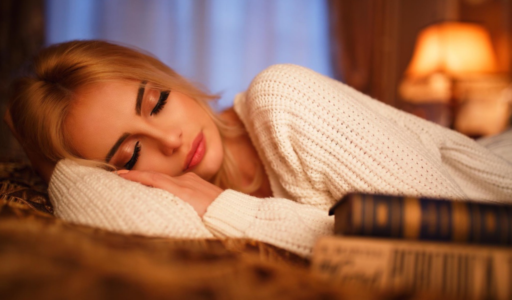 Нежная спящая блондинка в белом свитере 