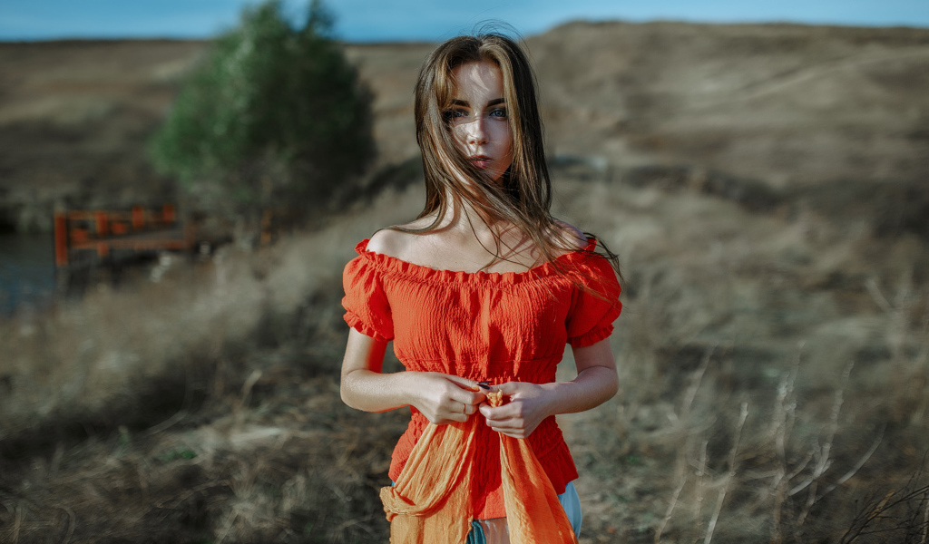 Ветер развивает волосы красивой девушке шатенке 