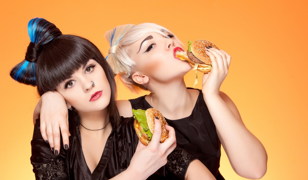 Две девушки с ярким макияжем с гамбургерами