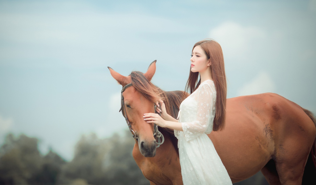 Молодая азиатка в белом платье с лошадью 