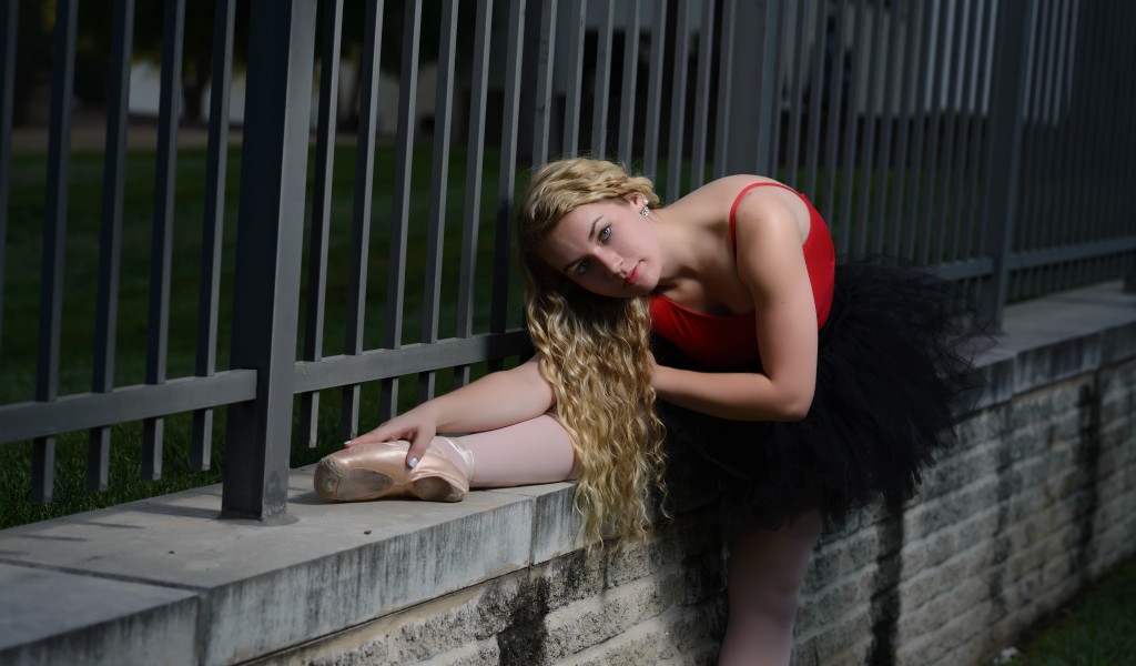 Молодая красивая девушка балерина делает растяжку