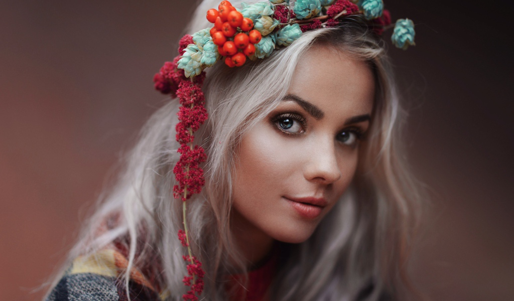Молодая голубоглазая девушка с венком на голове