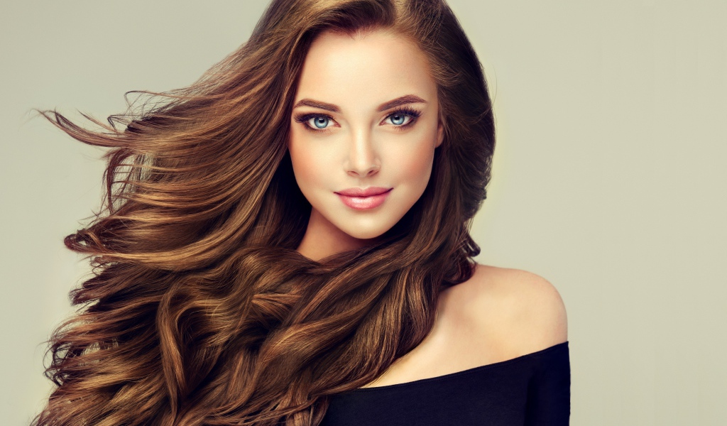 Молодая голубоглазая девушка с красивыми длинными волосами