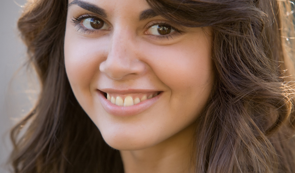 Молодая кареглазая брюнетка с очаровательной улыбкой