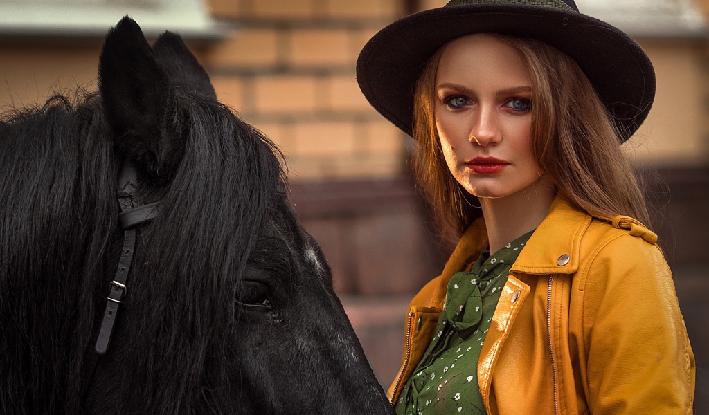 Молодая девушка в черной шляпе с конем 