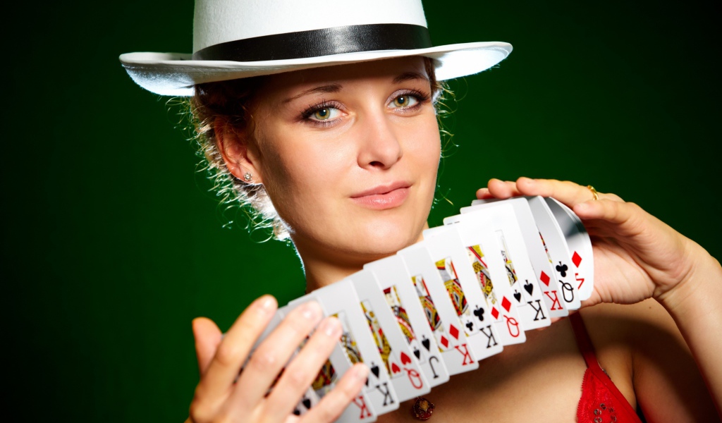 Молодая девушка в шляпе с картами в руках
