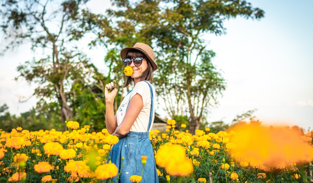Молодая девушка в солнечных очках в желтых цветах 