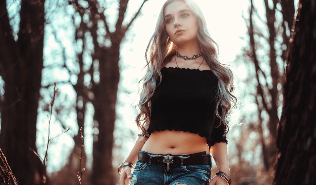 Молодая девушка в рваных джинсах с пирсингом в носу