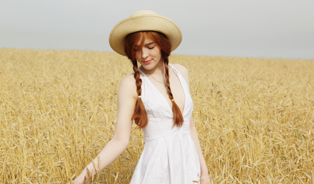 Молодая девушка в белом платье на поле с пшеницей