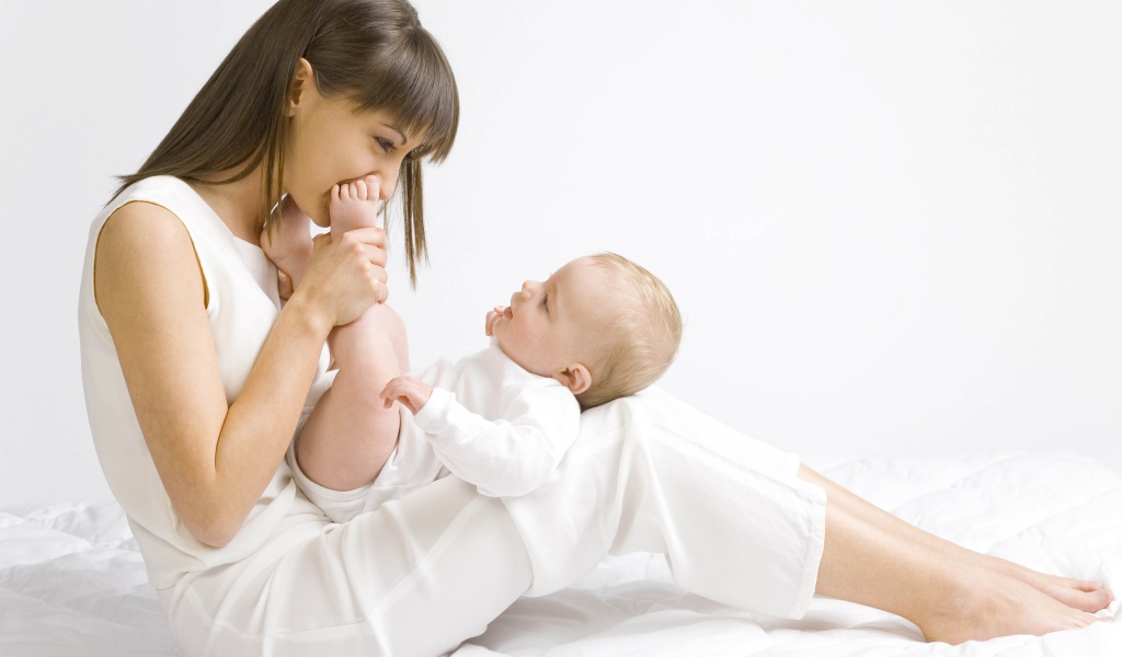 Молодая девушка в белом с младенцем